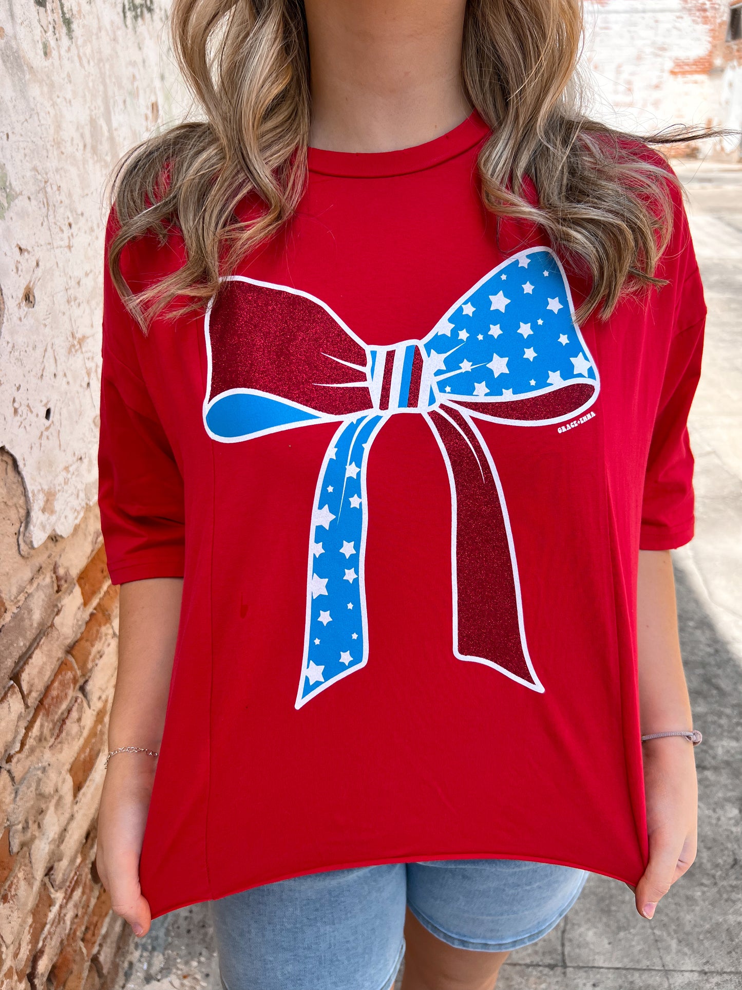 Red White And Blue Bow Tee Shirt-Apparel & Accessories-Southern Grace Wholesale-06/18/25,6893e-red-bow,FD 04/09/24,Max Retail,Tops Collection-The Twisted Chandelier